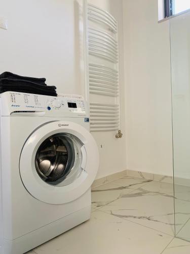 a white washing machine sitting in a room at Style Inn Apartmanok in Veszprém