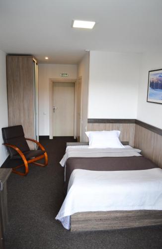 a hotel room with two beds and a chair at VILSON hotel in Bukovel