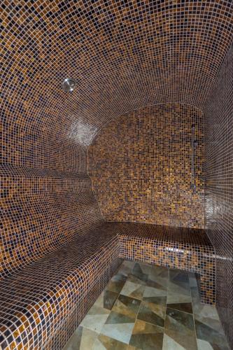 a brown tiled bathroom with a tub in a room at "Indian Summer" Apartment in Viljandi