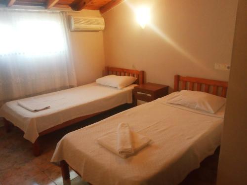 two beds in a small room with a window at Dove Apart Hotel in Fethiye