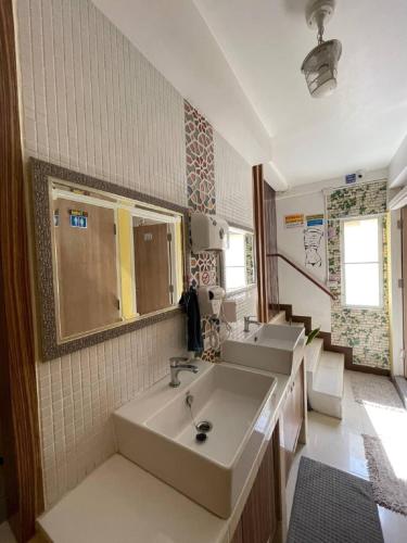 a large bathroom with two sinks and a mirror at Great House 99 in Bangkok