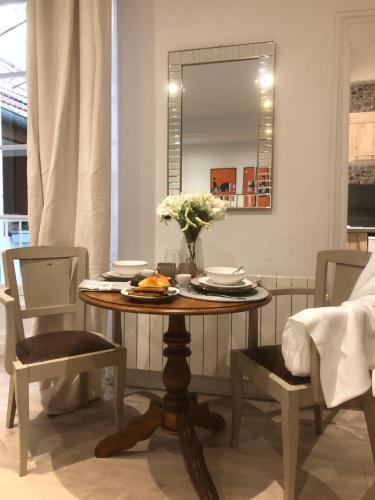 une table de salle à manger avec deux chaises et un miroir dans l'établissement Ô’Hospices : Coeur de Beaune, à Beaune