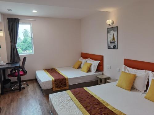a hotel room with two beds and a window at MORNINGS HOTEL in Sungai Petani