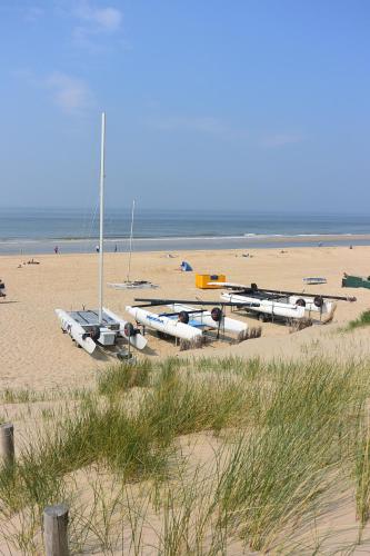a group of boats sitting on a sandy beach at Strandhotel Golfzang in Egmond aan Zee