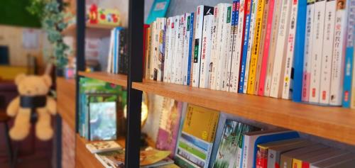 rząd książek na półce w obiekcie On One Side Homestay w Lugu