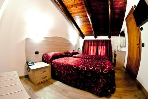 a bedroom with a red bed and a table at Agriturismo Cascina del Vai in Cairo Montenotte