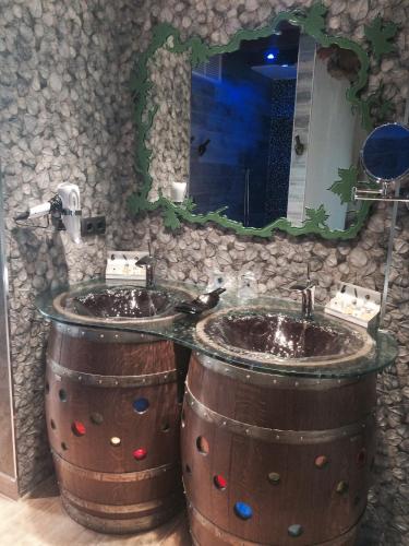 a bathroom with two sinks in two wooden barrels at Hotel SPA El Lagar de Isilla in La Vid y Barrios