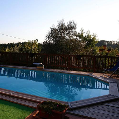 a swimming pool in a yard with a wooden fence at Agriturismo il Poggetto in Torre