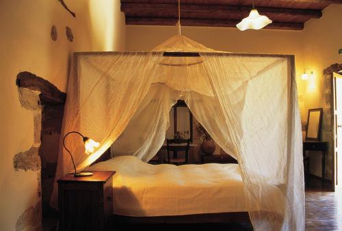 a bedroom with a bed with a mosquito net at Elia Hotel & Spa in Áno Voúvai