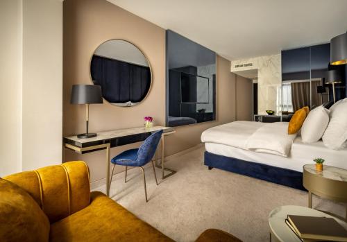 a hotel room with a bed and a desk at Grand Hotel Adriatic in Opatija