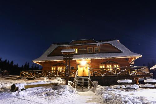 a log cabin in the snow at night at Koliba u Kuba a rekreačné domy in Hruštín
