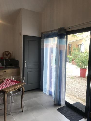 a room with a door and a table and a table and a window at Matin de Saône in Fontaines-Saint-Martin