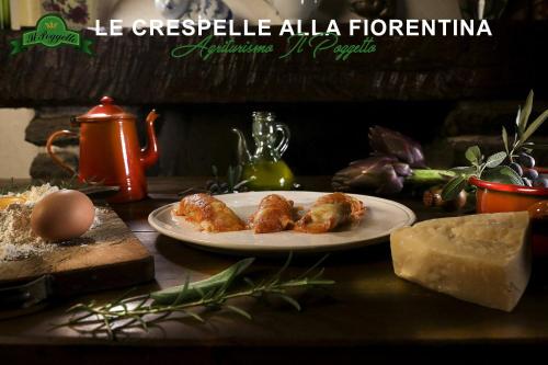 a plate of food on a table with cheese and bread at Agriturismo il Poggetto in Torre