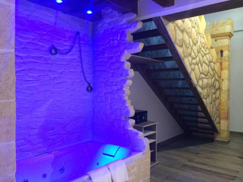 a room with a purple brick wall with a bathtub at Hotel SPA El Lagar de Isilla in La Vid y Barrios