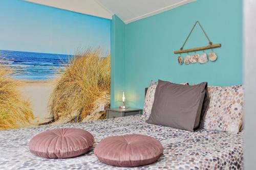 een slaapkamer met een bed met 2 roze kussens bij Appartement Scheepswerf in Burgh Haamstede