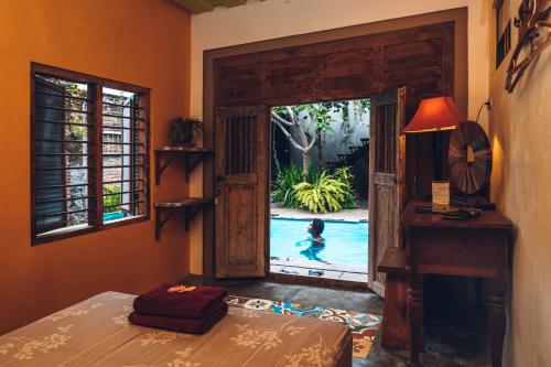 a bedroom with a door open to a swimming pool at Nextdoor Rooms in Yogyakarta