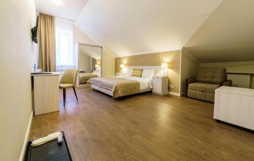 a hotel room with a bed and a chair at ROSSI HOTEL in Tver