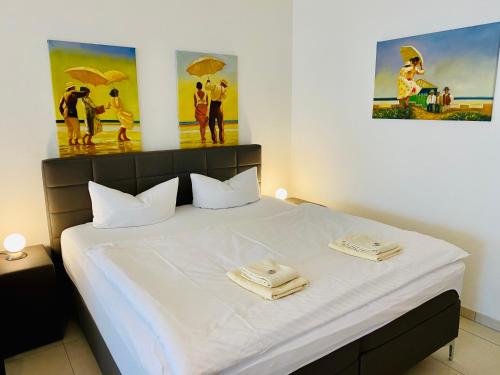 ein Schlafzimmer mit einem weißen Bett mit zwei Handtüchern darauf in der Unterkunft Villa Seepark - Ferienwohnung 2 in Heringsdorf