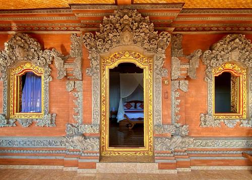 a room with a bed in the middle of a building at Gayatri in Ubud