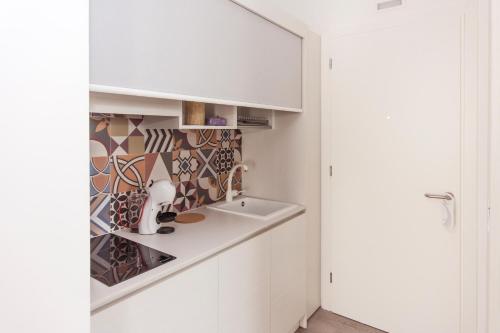 uma cozinha com um lavatório e um armário em Hotel Residence - Il Giardino del Cigno em Latisana