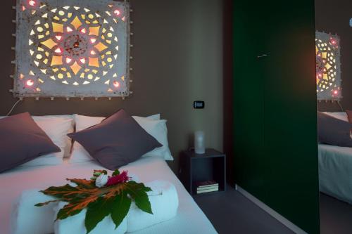 a bedroom with a bed with a flower arrangement on it at Villa Roberta by HDSalento in Specchiolla 