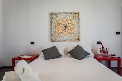 a bedroom with a large white bed with two red tables at Villa Roberta by HDSalento in Specchiolla 