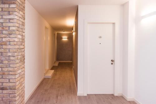 a hallway with a brick wall and a white door at Hotel Residence - Il Giardino del Cigno in Latisana