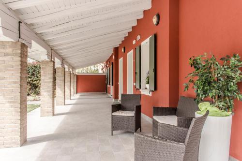 a corridor of a building with orange walls and chairs at Hotel Residence - Il Giardino del Cigno in Latisana