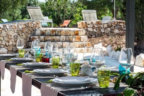 a table with wine glasses and plates on it at Villa Roberta by HDSalento in Specchiolla 