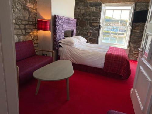 a hotel room with a bed and a chair at Harbourmaster Hotel in Aberaeron