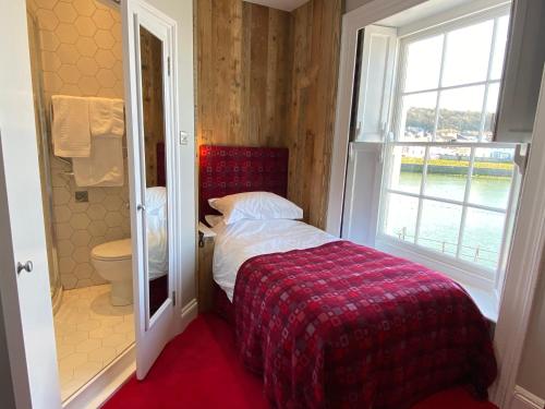 a small bedroom with a bed and a window at Harbourmaster Hotel in Aberaeron