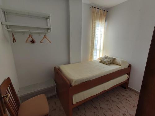 a small bedroom with a bed and a window at Apartamento Conil Zona tranquila con fácil aparcamiento in Conil de la Frontera