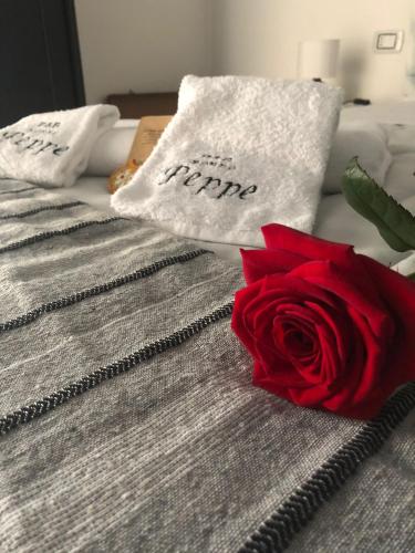 uma rosa vermelha sentada em cima de uma cama em b&b nonno peppe em Palermo