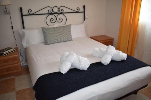 two towels on a bed with two stuffed animals on it at Hotel El Ancla in Villanueva de la Cañada