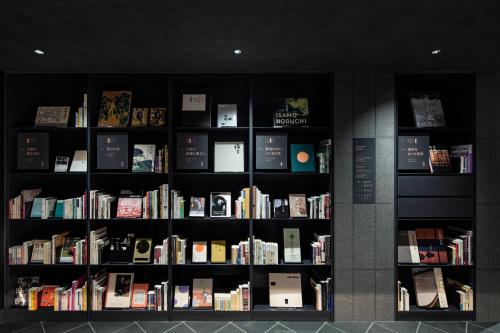 a book shelf filled with lots of books at hotel tou nishinotoin kyoto in Kyoto