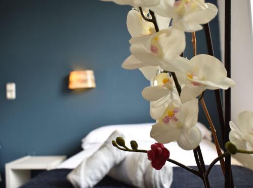 a bouquet of white orchid flowers in a bedroom at Hotel El Ancla in Villanueva de la Cañada