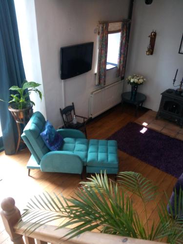 a living room with a blue couch and a television at The Threshing Barn in Harrogate