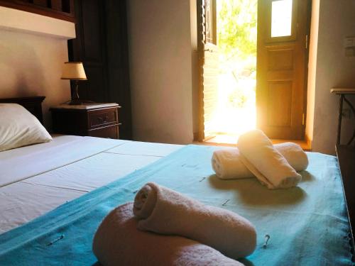 a bedroom with a bed with towels on it at Machi's House in Plaka Milou