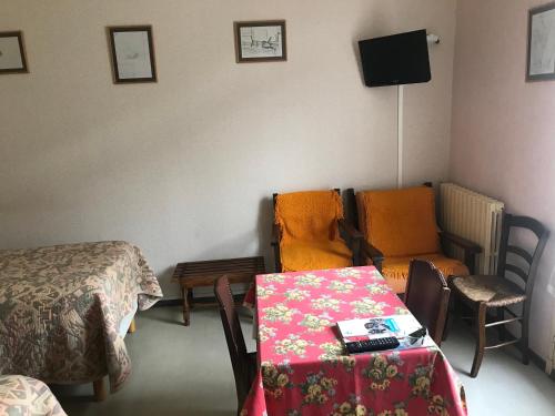 a room with a bed and a table and a chair at Hébergements à La Rive, Accueil ouvert tous les jours jusqu'à 20h00 dernier délai, depuis 30 ans ! Réserver ici svp ! Merci ! Aucun règlement à distance accepté, Paiement par CB, Espèces, Chèque ou Chèques-Vacances impérativement à la remise des clefs ! in Amélie-les-Bains-Palalda
