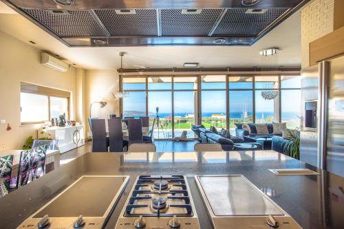 een keuken en een woonkamer met een kookplaat. bij Luxury 6-Bedroom Villa With Private Pool- Villa Prigipessa in Chania