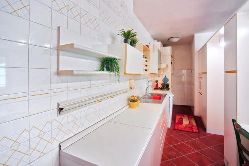 een keuken met witte kasten en een rode vloer bij Casa Garibaldi in San Vincenzo