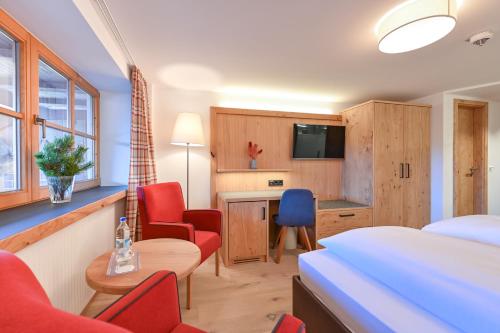a hotel room with a bed and a desk and chairs at Hotel Helmer in Schwangau