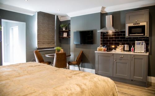 a room with a kitchen and a table with chairs at The Hotel Chester in Chester