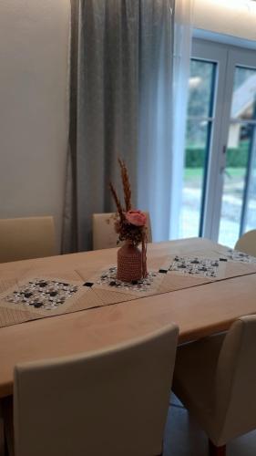 a table with a vase of flowers on top of it at Ferienhaus und Apartment Idolsberg in Idolsberg