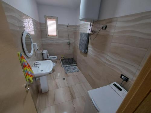 a small bathroom with a sink and a toilet at Bral Apartments in Durrës