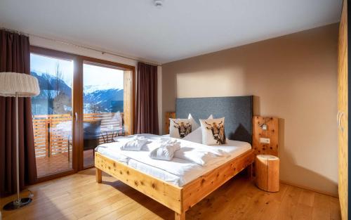 a bedroom with a bed and a large window at Tanafreida Berg-Refugium in Sankt Gallenkirch