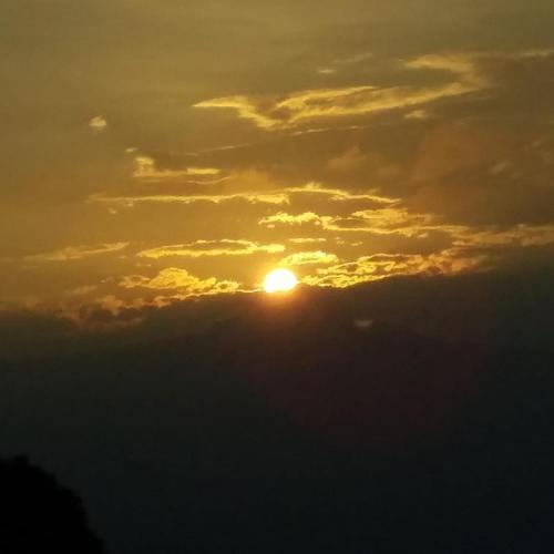 a sunset with the sun in the clouds at Vamoose Rigzen in Pedong