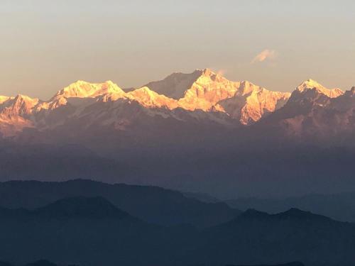 a group of mountains with the sun shining on them at Vamoose Rigzen in Pedong