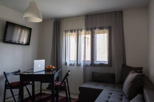 a living room with a couch and a table with a laptop at JELA Countryside House in Kosjerić