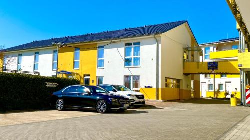 two cars parked in a parking lot in front of a building at i-Motel in Obertshausen